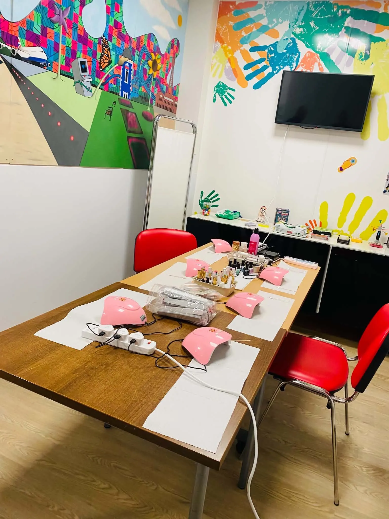 Colourful activity room with tables, practical supplies and wall art